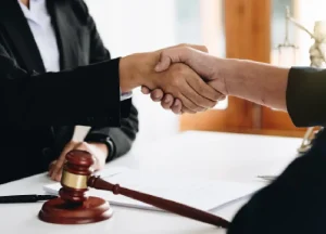 Why Hiring a Mesothelioma Lawyer Early Matters 2 Lawyer shaking hands with a client during a legal consultation.