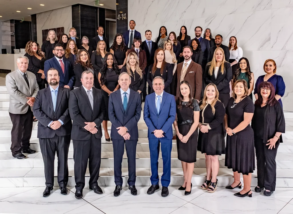 Legal team of Danziger & De Llano, LLP standing together on a staircase