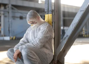 Worker handling asbestos in protective gear