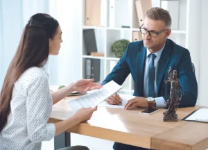 How Asbestos Trust Funds Are Calculated: Scheduled vs. Individual Review Explained 1 Lawyer explaining documents to a client, illustrating trust management and legal guidance.