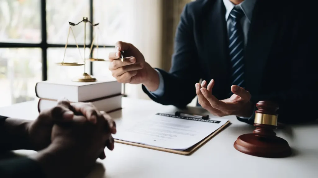 Lawyer explaining the details of a VA claim and mesothelioma lawsuit to a veteran client in an office.