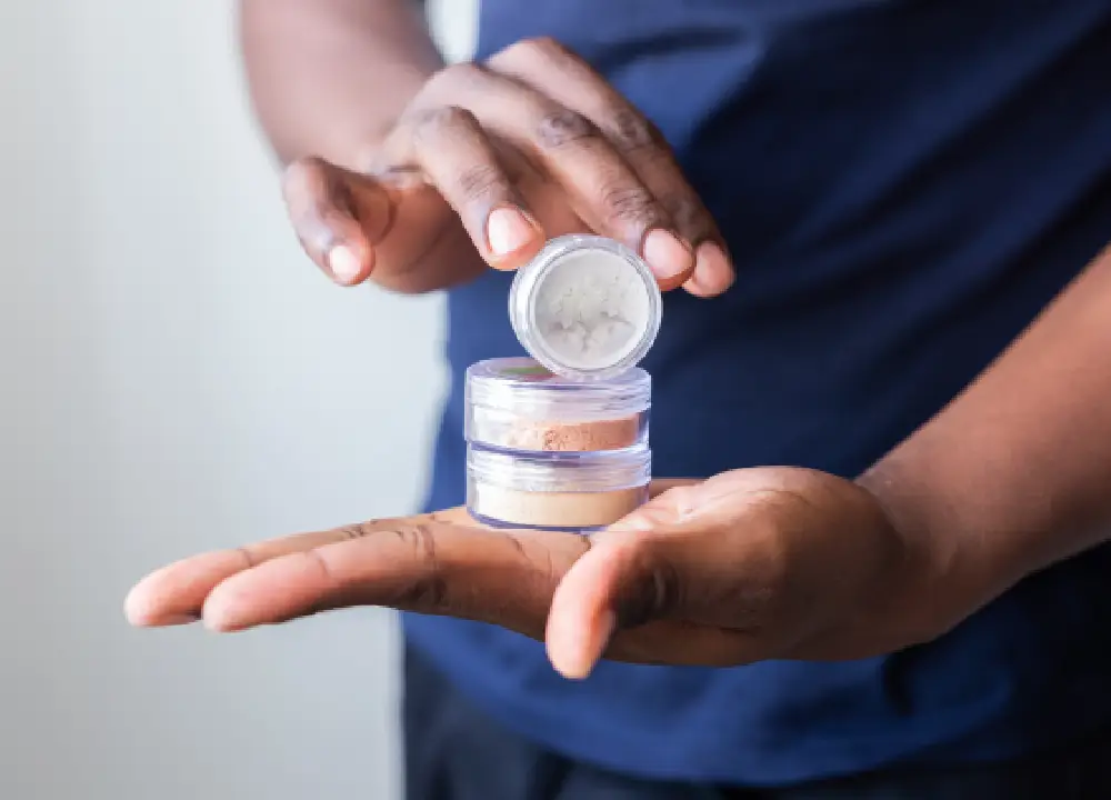 Person holding a cosmetic container while examining the product.