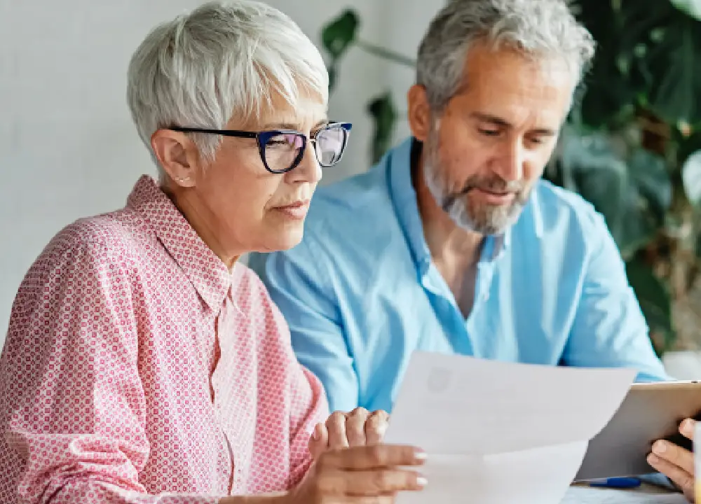 A Complete Guide to Mesothelioma Cancer: From First Symptoms to Legal Rights 2 Senior couple at home reviewing medical bills and financial documents with a serious expression.