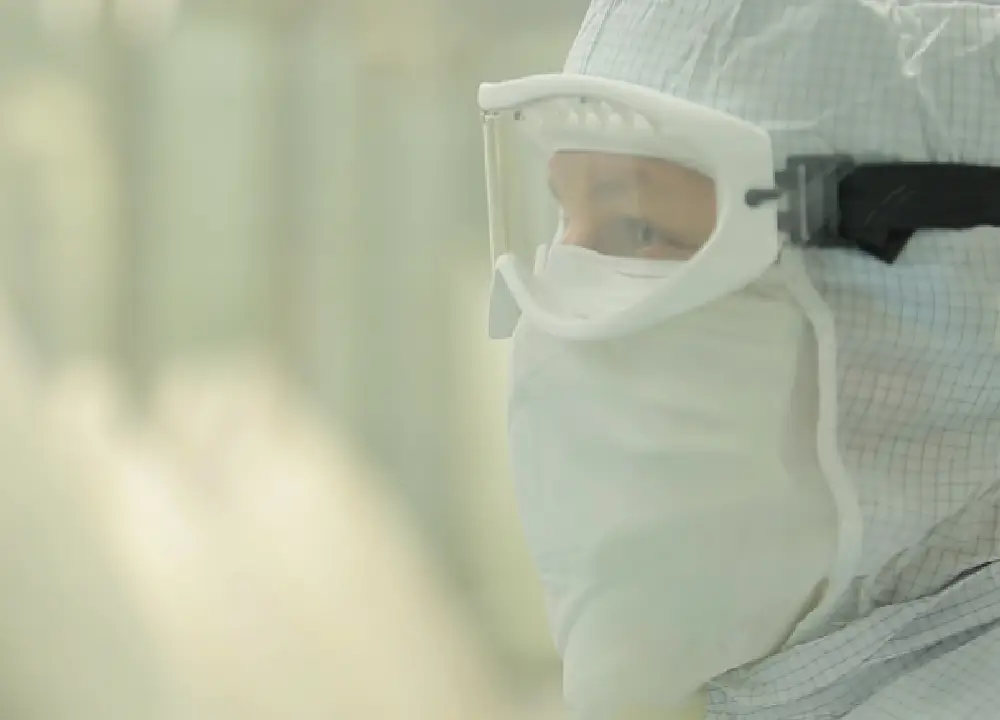 Navigating Compensation Claims for Occupational Talc Exposure 1 An industrial worker in a protective lab coat and mask, representing workers exposed to contaminated talc in manufacturing settings.