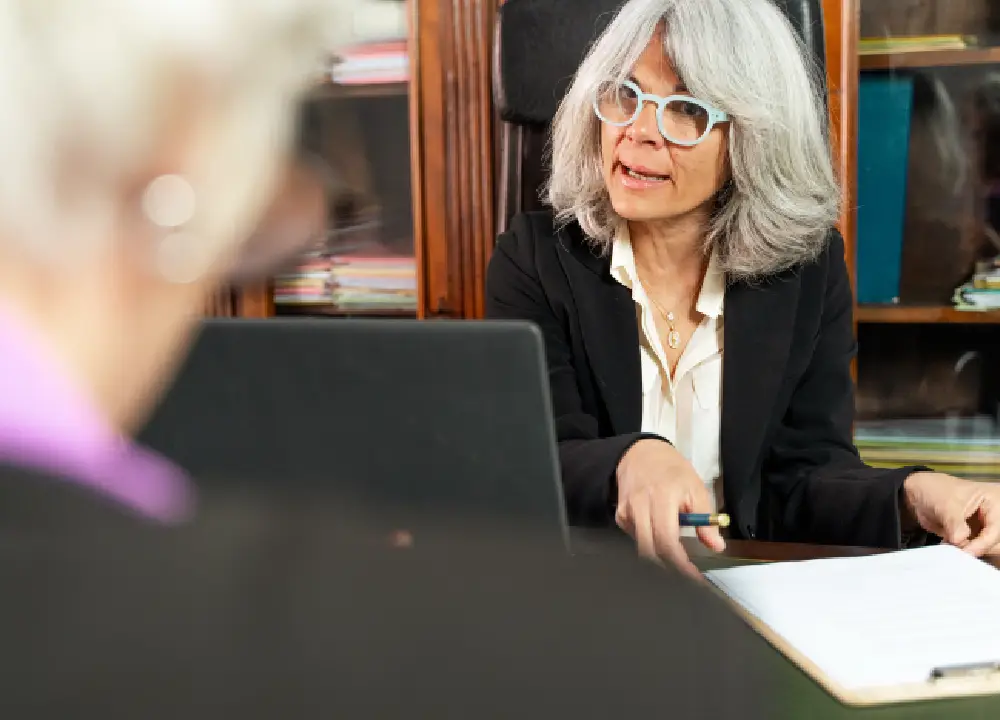 Navigating Mesothelioma Cancer: Essential Info and Support 2 Experienced lawyer consulting with a client and reviewing legal documents in an office.