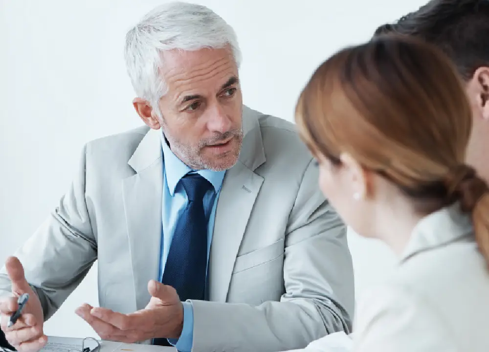 Lawyer explaining compensation options to a couple during a legal consultation.
