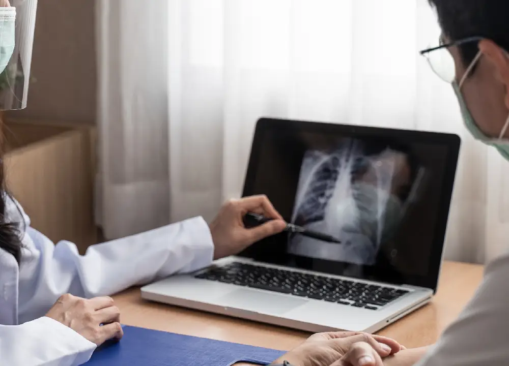Mesothelioma Symptoms Explained: A Beginner's Essential Guide 1 Doctor explain x-ray chest result in computer to man patient in examination room in hospital.