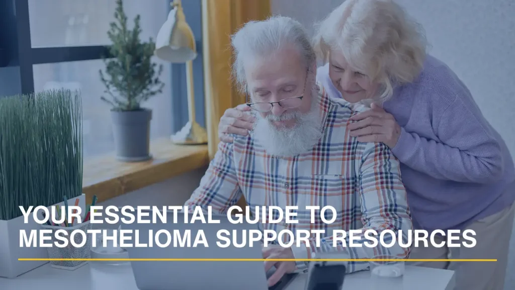A senior couple sitting on a sofa using a laptop to research mesothelioma support groups and resources.