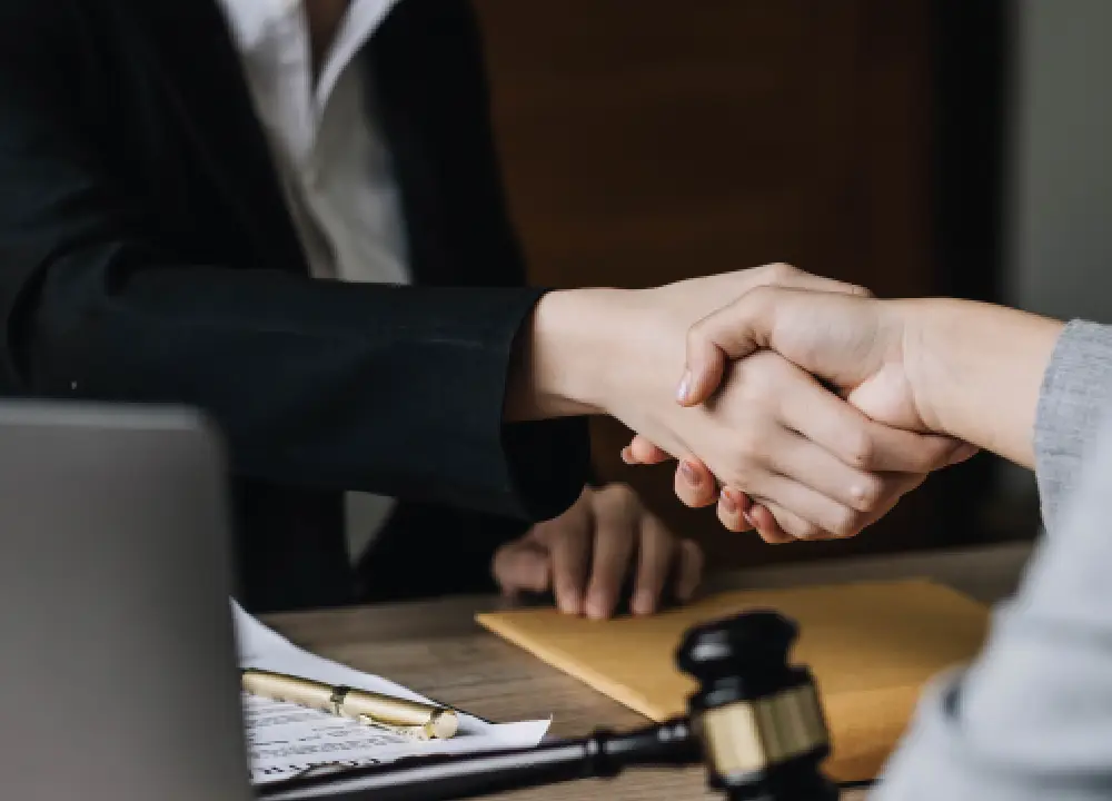 Your Guide to Talc and Asbestos Exposure Risks and Legal Options 3 Lawyer shaking hands with a client after a legal consultation.