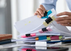 Mesothelioma Claims: The Documentation-First Guide 2 Hands organizing medical records and patient files on a desk to prepare documentation for a mesothelioma claim