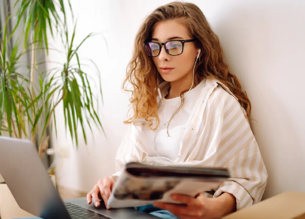 Person reading news on a laptop in a professional setting.