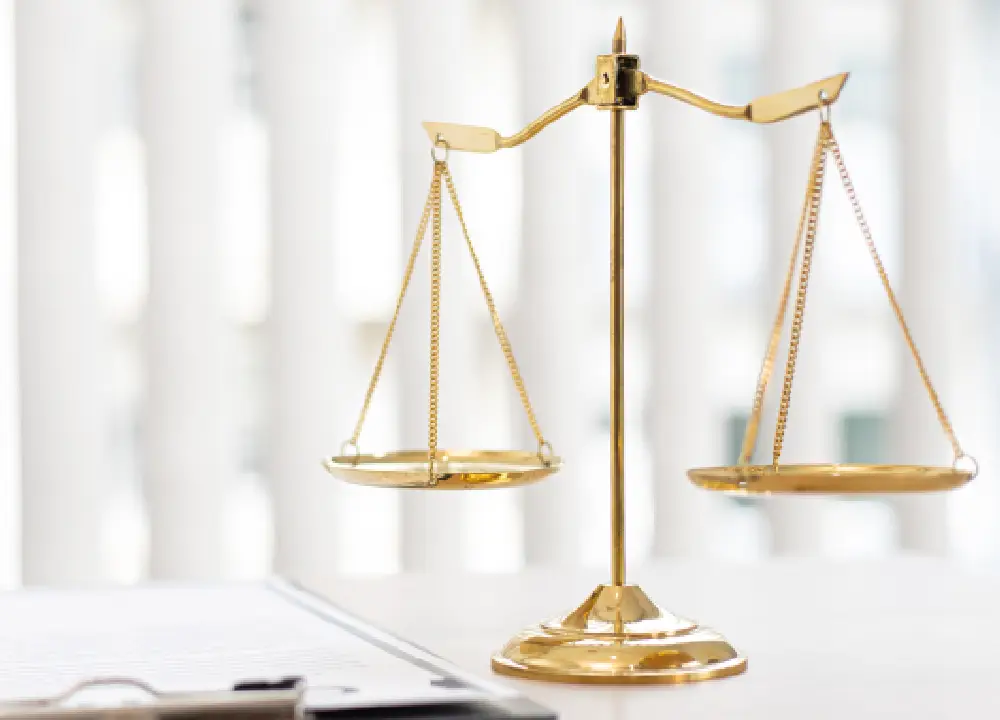 Mesothelioma Explained: Path to Justice and Compensation 2 Scales of justice displayed beside legal documents on a desk.