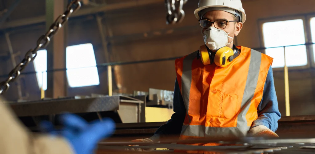 concerned worker wearing a protective mask and helmet at a dusty, industrial site