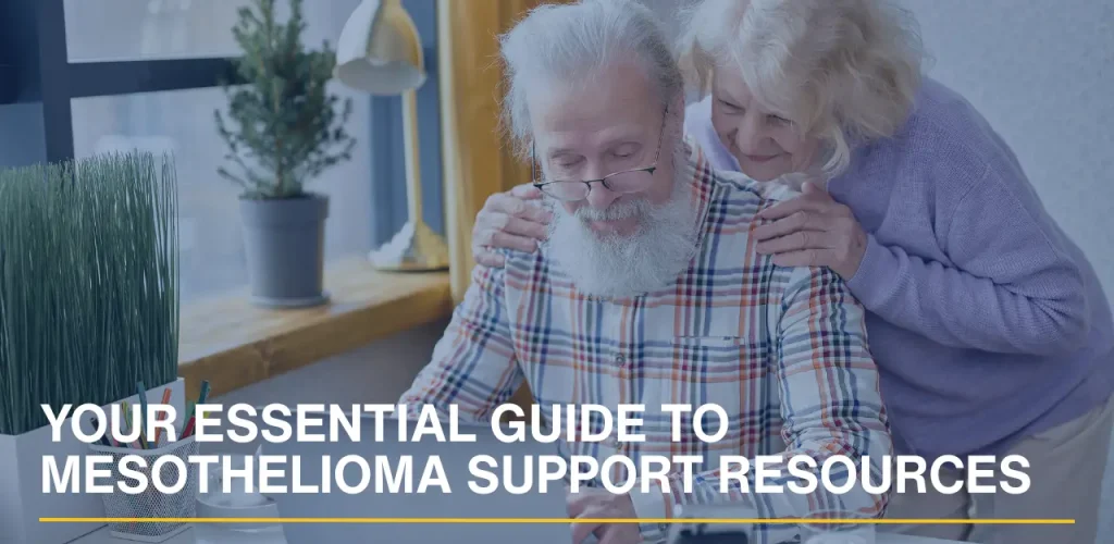A senior couple sitting on a sofa using a laptop to research mesothelioma support groups and resources.
