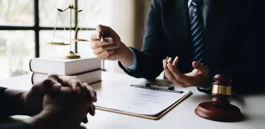 Lawyer explaining the details of a VA claim and mesothelioma lawsuit to a veteran client in an office.